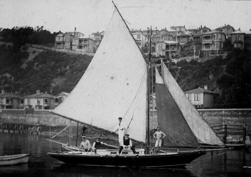 Shows the Mahaki with sails up and sailors on deck posing for photo.