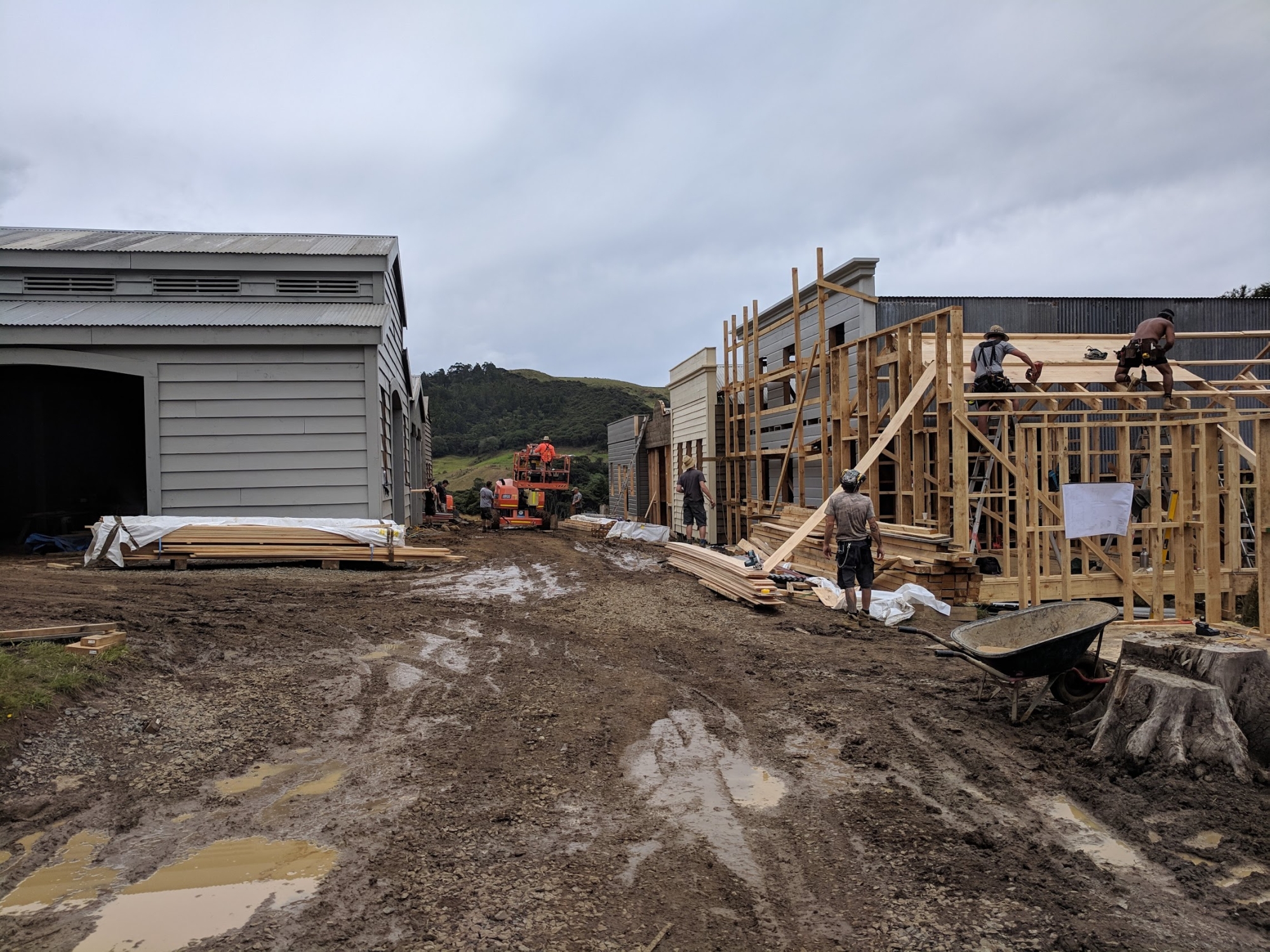 Half-built houses line a muddy street as the set begins to take shape.
