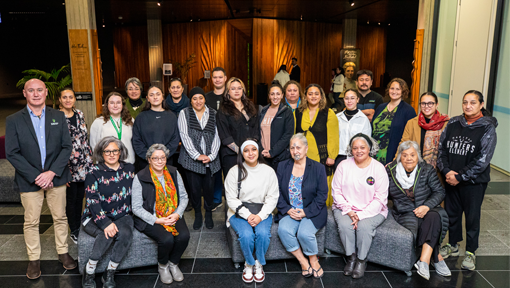 Group photo of Māori men and women at the National Library Te Puna Mātauranga o Aotearoa.