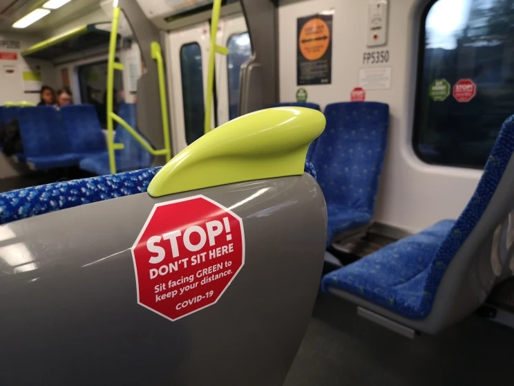 Sticker for seat back in the shape of a red stop sign for public buses and trains to maintain social distancing.