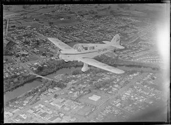 An old black and white photograph for an airplane sailing over New Zealand towns