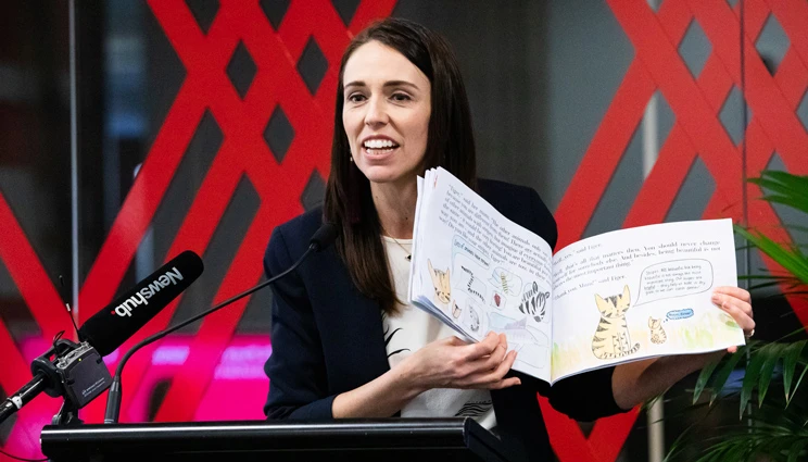 Prime Minister speaking at the event holding a book