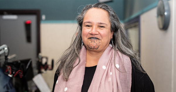 Smiling Māori woman with a moko kauae.