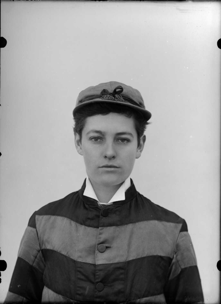 A portrait of a woman wearing a jockey shirt and cap shows her staring into the camera lens with a wistful if ambiguous expression.