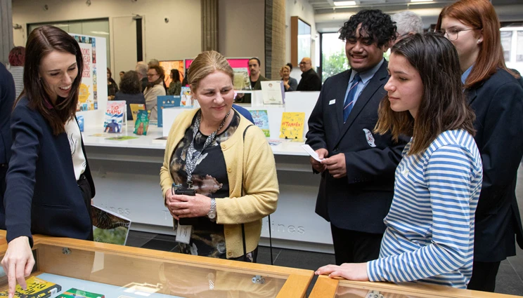 Prime Minister Jacinda Arden, Elizabeth Jones, Tien Ngahere, Katie-Rose Janmaat, and Jean Cleaver-Paris looking at a display of children's books at the Celebration of Reading event