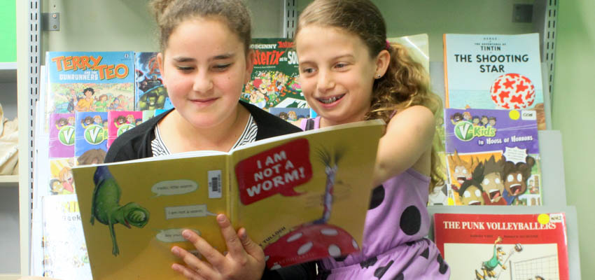 2 tweens enjoying sharing a book