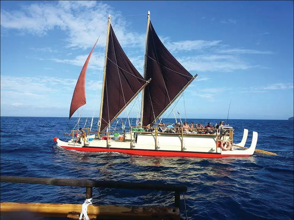 Colour photograph of waka hourua Ngāhiraka Mai Tawhiti sailing on the ocean with crew on board.