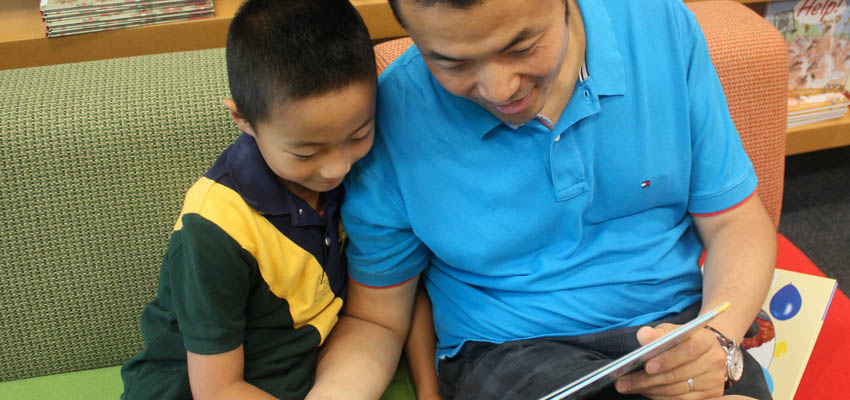 A father and his son reading together.