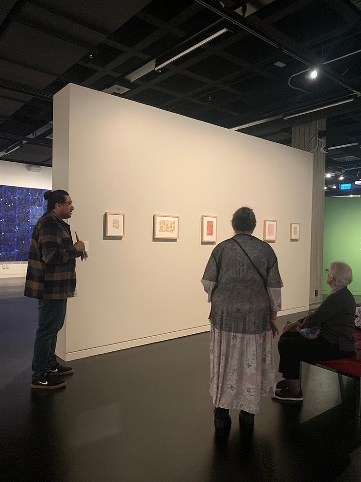 People looking pictures in an exhibition space. 