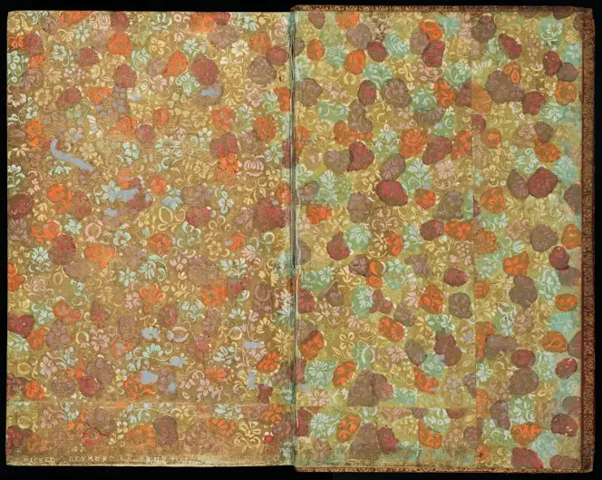 Gilt paper with an intricate floral pattern, coloured in blots of yellow, orange, green, and brown.