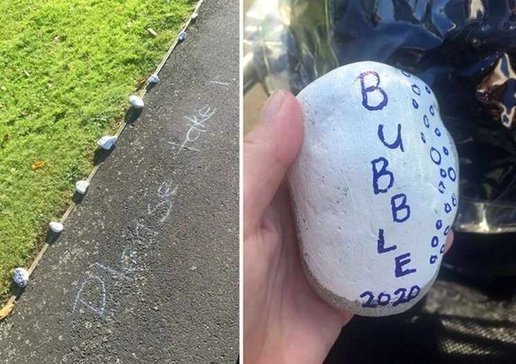 Side by side images of street art featuring a series of rocks along the footpath that are all painted white with blue writing that reads, 'Bubble 2020' shown in detail in image on the right, on the left the footpath has writing next to the rocks that reads, 'Please take'.