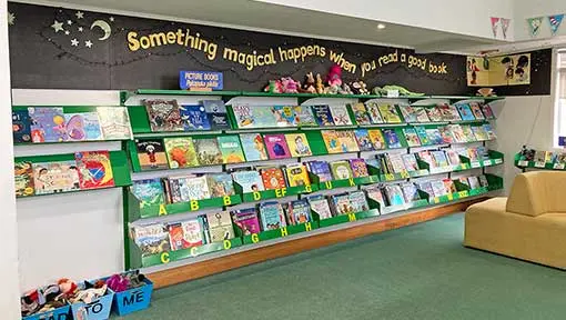 Picture books on wall shelves in a school library.