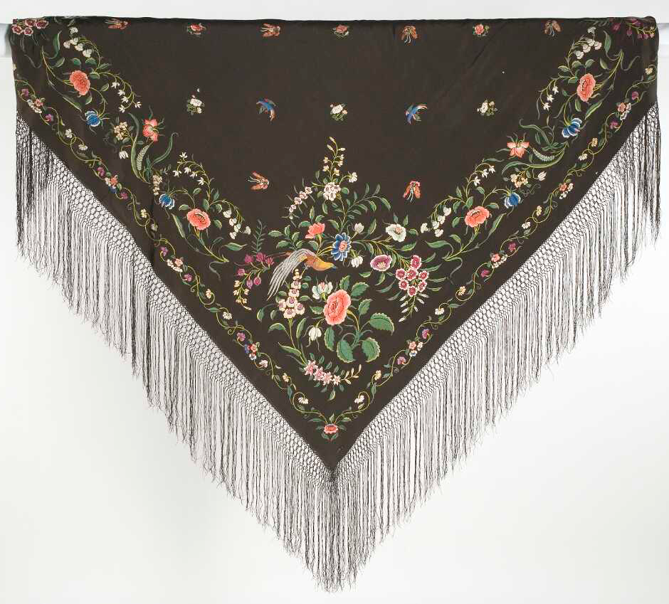 Detail of a black shawl showing beautiful colourful embroidery of flowers, a bird and butterflies