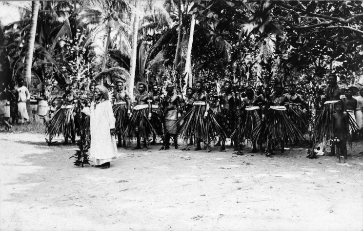 Queen Tenia'makui with Banaba Island men in traditional clothing at Tabwewa village during a ceremony.