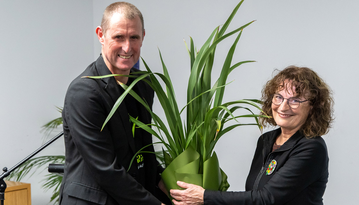 Alan Dingley passing a harakeke (flax) to Kate De Goldi.