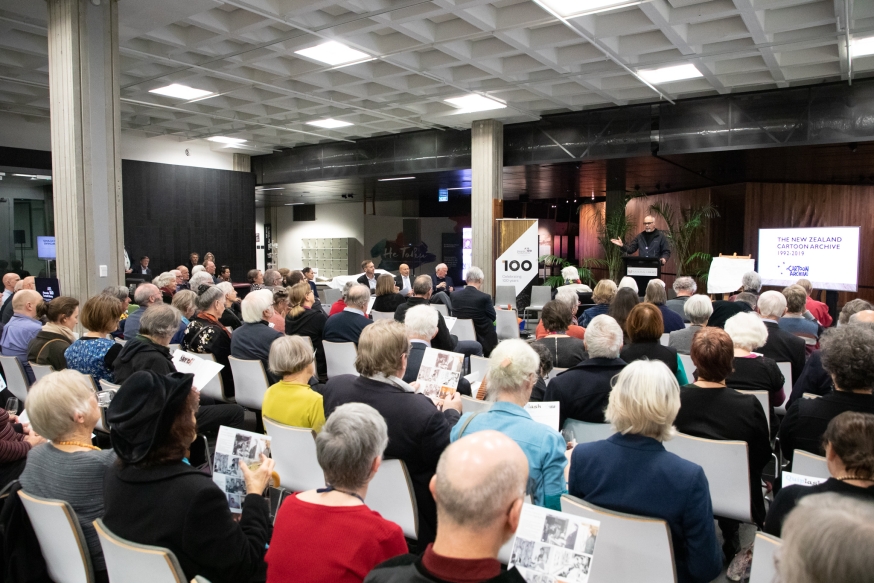 Photo taken from the back of the audience with Paul Diamond standing behind a lecturn at the front of the room.