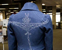 Back of a jacket with embroidery of a flying creature. 