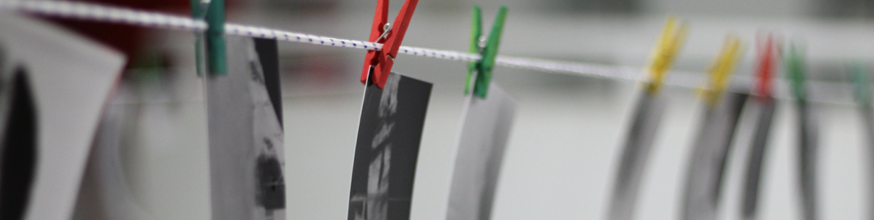 Photographs hanging on an inside clothesline. 