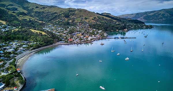 Photo showing a view of Akaroa overlooking the town, landscapes and harbour.