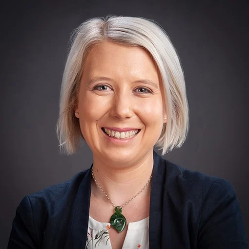 A head and shoulders portrait of a smiling woman.