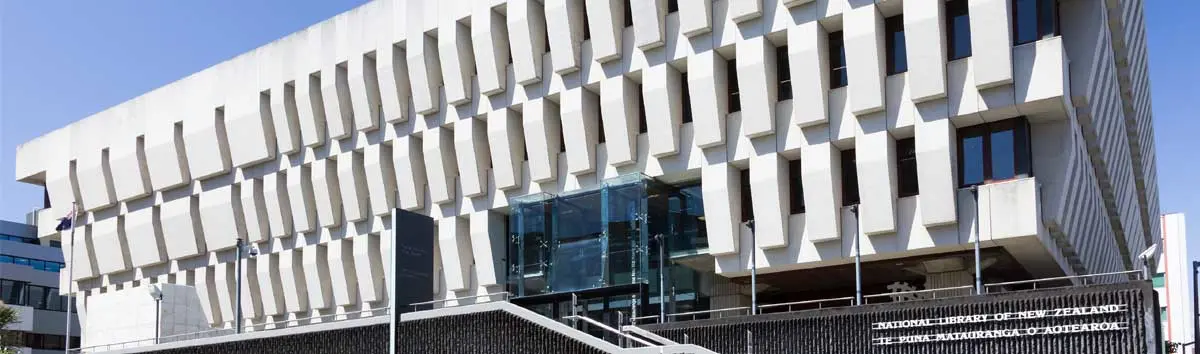 Modern white building with distinctive geometric facade featuring protruding rectangular elements against blue sky.