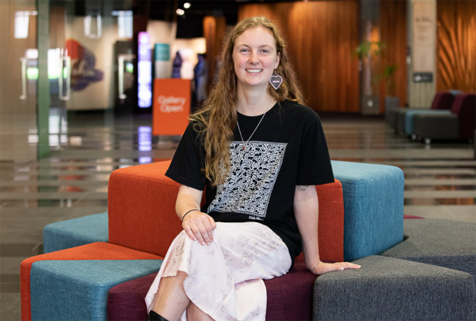 Smiling young woman sitting on colourful fabric blocks. 