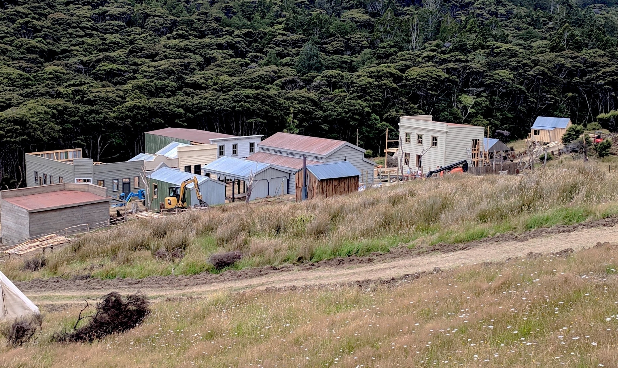 The set seen from the hill above showing half-built dwellings and a tractor in the process of constructing buildings.