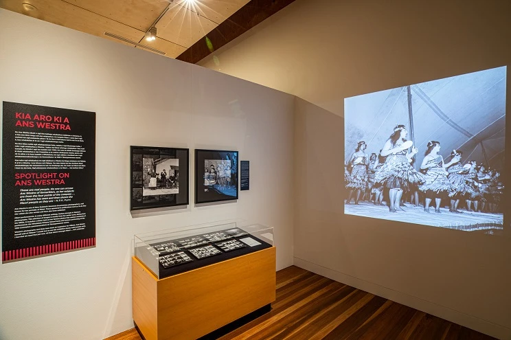 A scene from inside a gallery with black and white photographs on the wall.