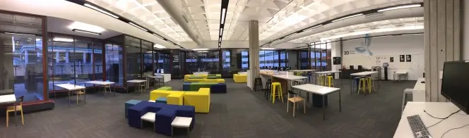 Panorama of the net.work space showing tables, chairs, computers, and 3D printers.