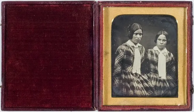 Daguerreotype image in its case, showing two sisters in mid-19th century clothing.