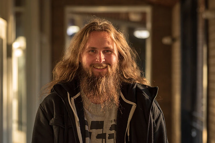 Smiling man with long hair and beard.
