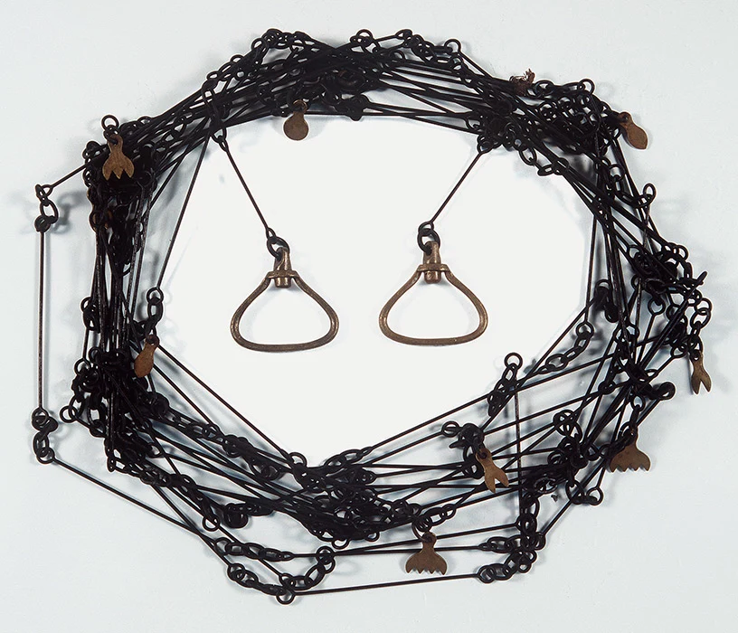 Colour photograph showing a coiled up surveyor's chain (also called a Gunter's chain). It is made of 100 steel rods, brass tags, and brass handles on each end.