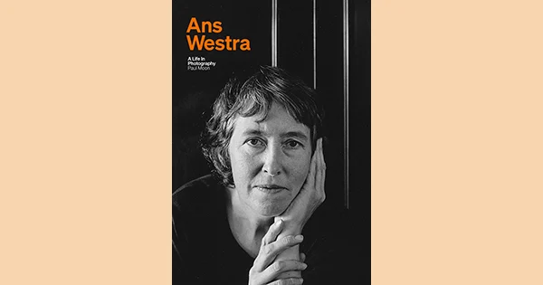 Book cover with a black and white photo of a woman resting her head in her hands and the text 'Ans Westra: A life in photography' in orange.