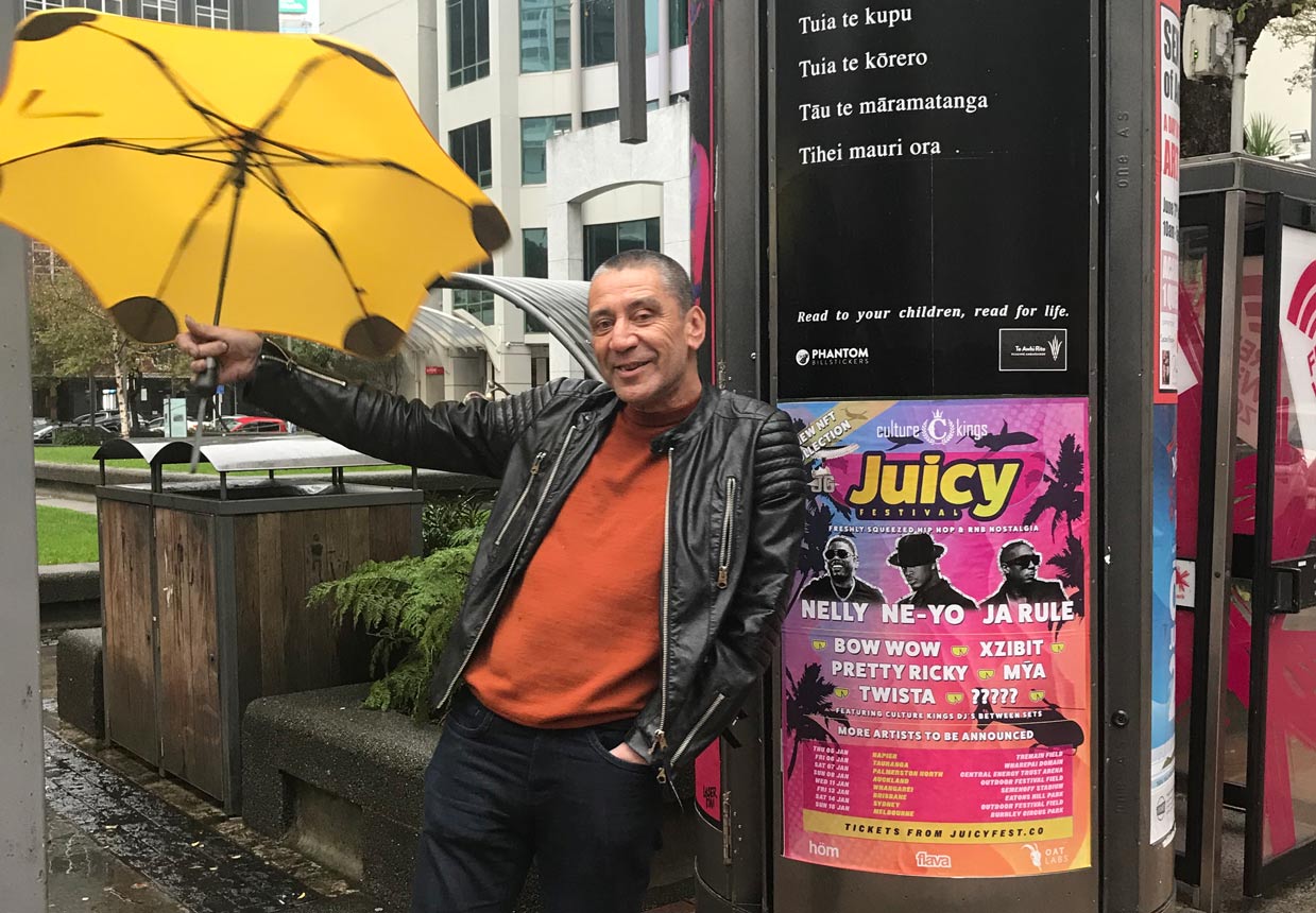 Ben holding a yellow umbrella in front of a Phantom poster with his tauparapara.