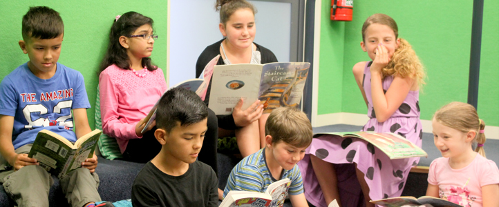 Class of students reading books in the school library
