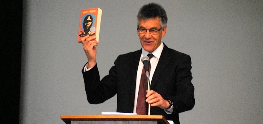 Mahurangi College principal making a speech and holding up a book