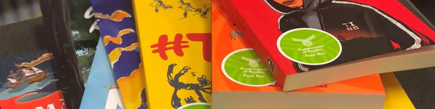 Detail from a photo showing colour books with the Communities of readers sticker on them.