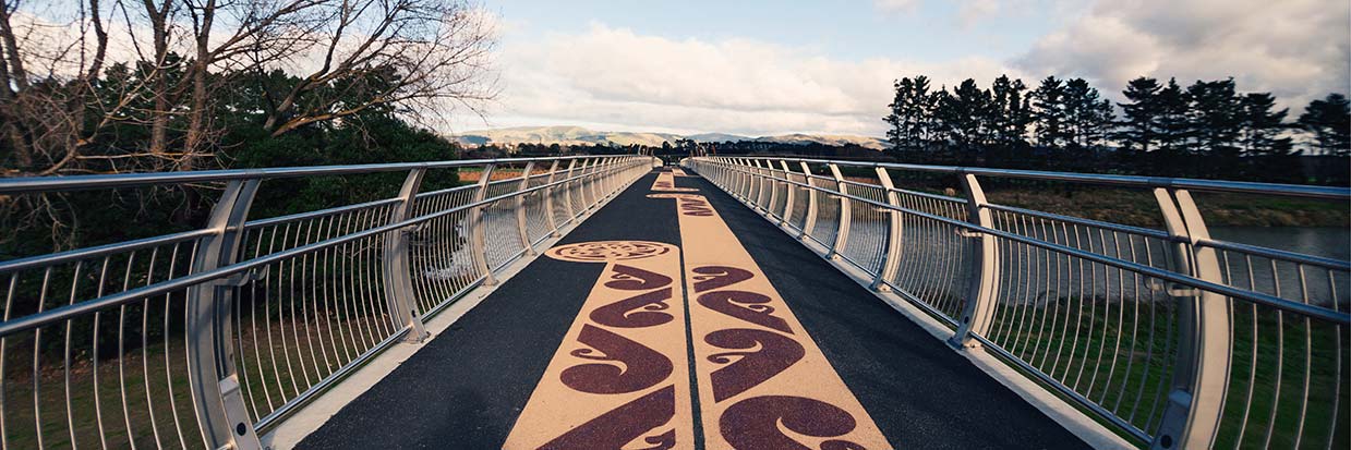 View of the He Ara Kotahi bridge in Palmerston North. The deck has koru patterns that run the length of the bridge.