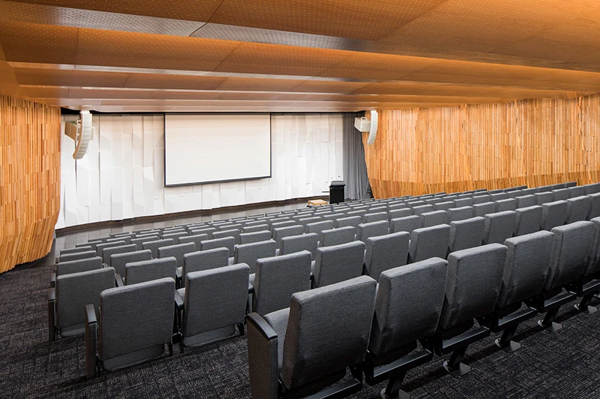 Empty auditorium showing seats, podium, and beautiful wood panelling.