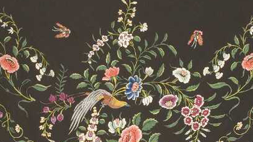 Detail of a black shawl showing beautiful colourful embroidery of flowers, a bird and butterflies.