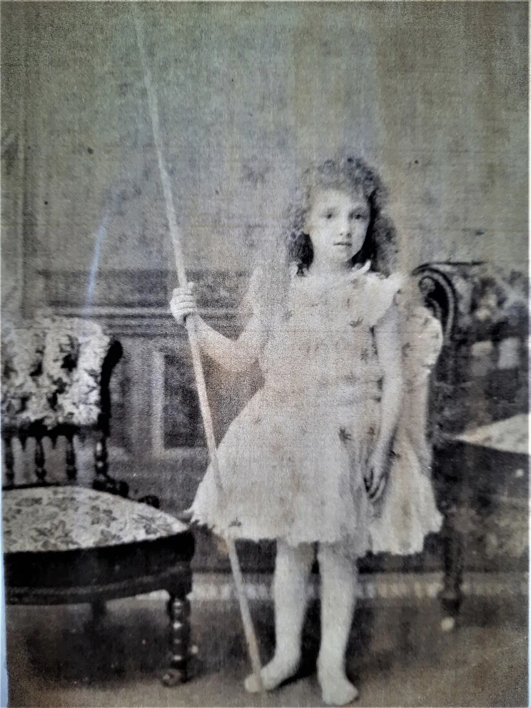 A blurry black and white studio portrait of a young girl in Victorian times.