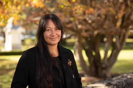 Woman standing in front of a tree.