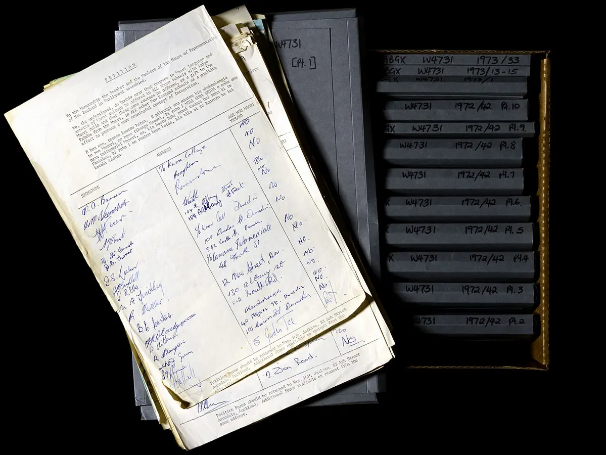 Colour photograph showing a collection of signed petition papers to introduce te reo Māori in schools in 1972.
