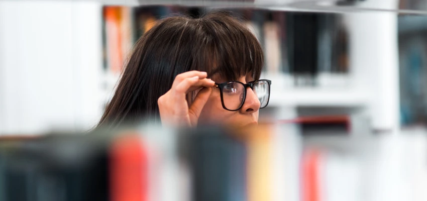 School librarian or teacher searching through shelves for childrens's and young adult (YA) books