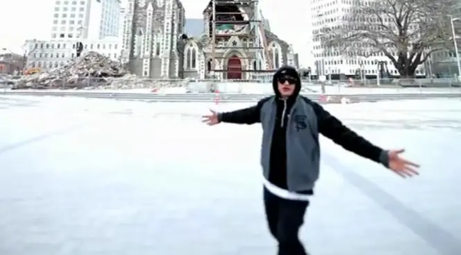 Screenshot from the Not Many Cities video, showing Scribe in front of the damaged Cathedral.