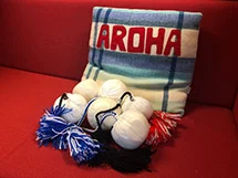 Cushion with the word Aroha on it and 6 poi.
