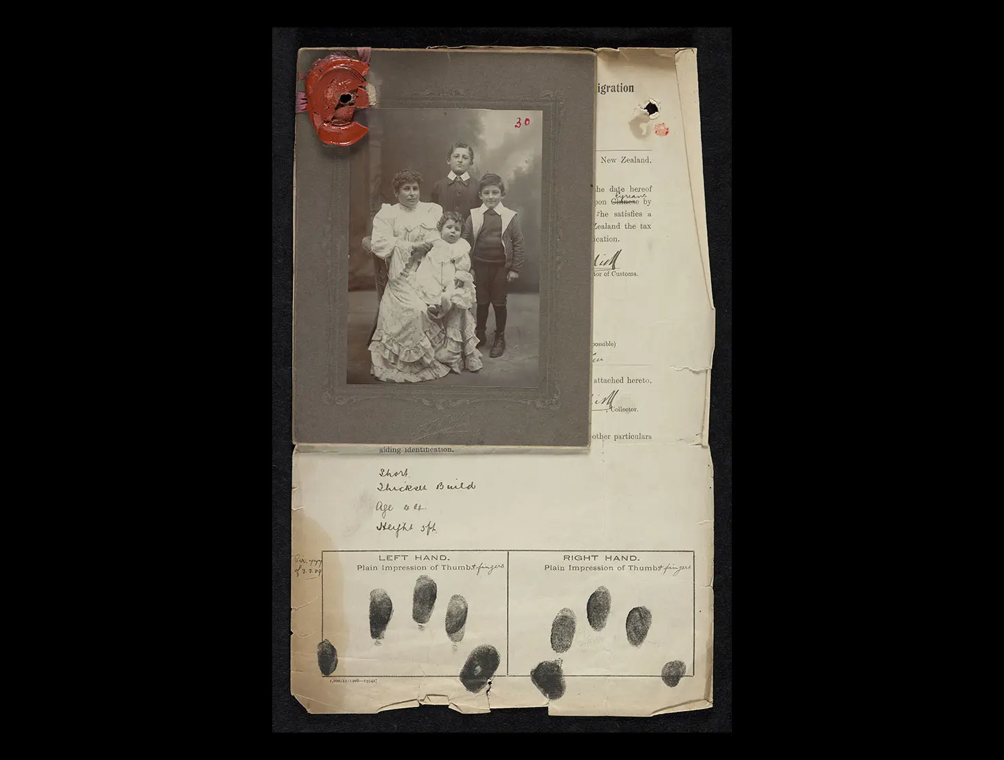 Certificate of registration for a Syrian family (Lily Khowi and her 3 children) entering Aotearoa NZ. It shows a black and white photo of them on top of a sheet with left and right-hand fingerprints for identification.
