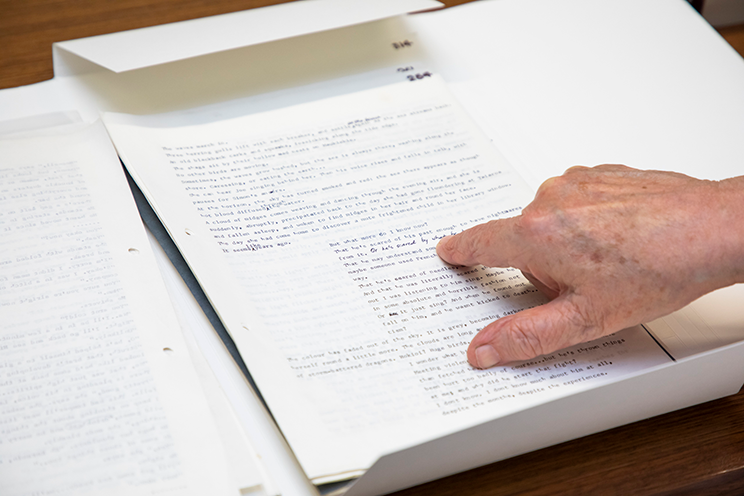 Hand pointing at something on a typed manuscript. 