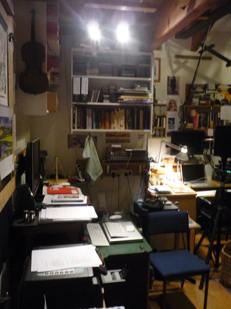 A dimly lit scene from inside a studio with papers and audio equipment.