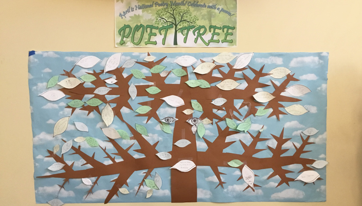 A dispay showing a Poet Tree artwork, with branches with 'leaf poems' hanging off them